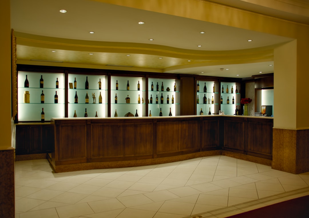 about-us a-wooden-bar-with-bottles-displayed-in-lighted-cabinets-gtk-22wlxxo